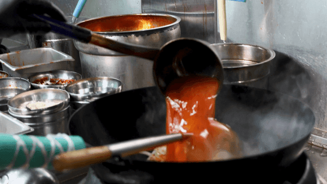 Jjamppong with spicy broth poured into wok