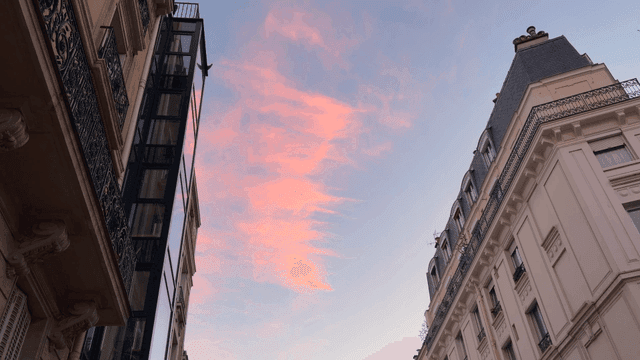 Sky with pink clouds above European buildings in city center