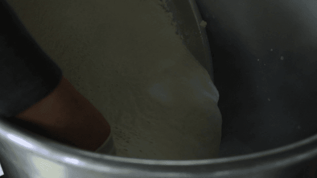 Dough poured from large metal bowl