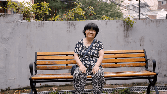 야외 벤치에 앉아 있는 노인 여성