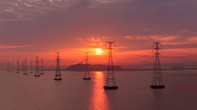 강 위 일몰 속 전선으로 연결된 송전탑