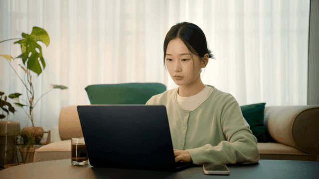 Woman working on her laptop in living room