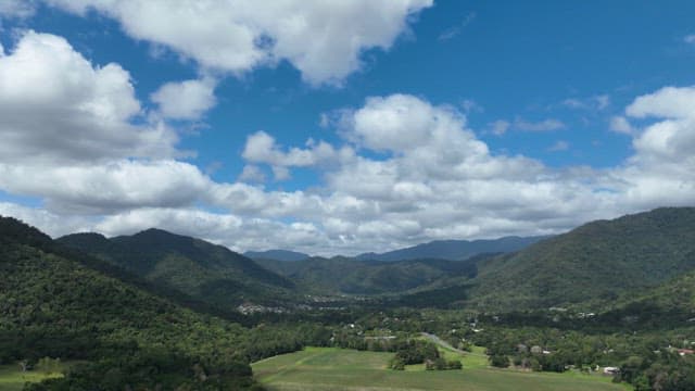 Green and lush mountains under a sky with white clouds