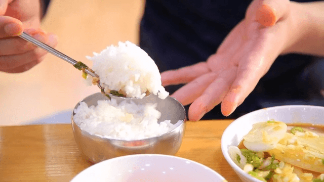 Person enjoying a meal with rice and stew