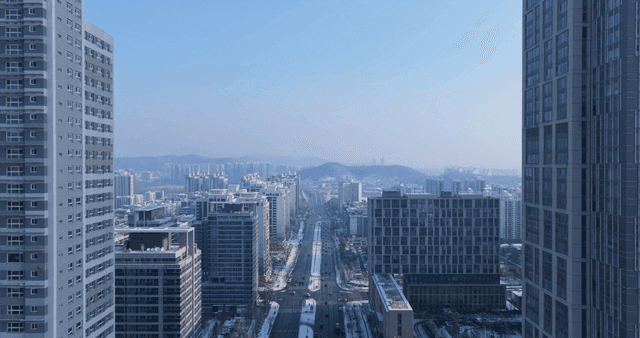 Snow-covered city landscape with tall buildings.
