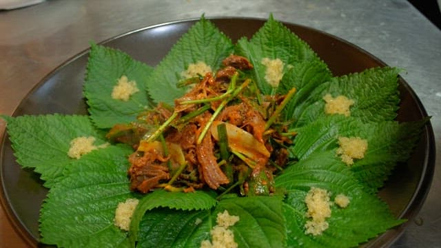 Seasoned meat plated with perilla leaves in the kitchen