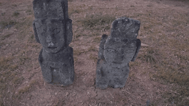 Traditional stone statues in a grassy field