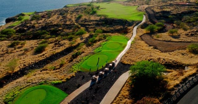 Golfers on a seaside golf course at sunset