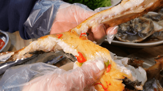 Hands tearing apart steamed dried rockfish on table
