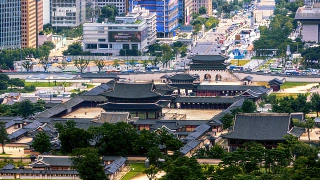 Elevated view of a traditional palace amidst city buildings and traffic