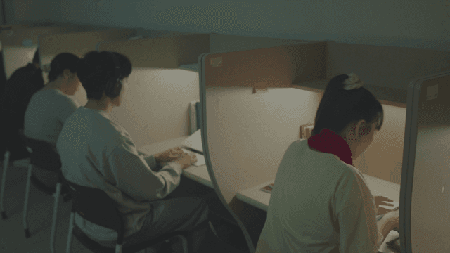 조용한 독서실에서 스마트폰을 보는 여학생