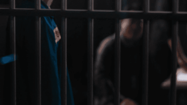 Prisoners and detectives behind bars in dark room