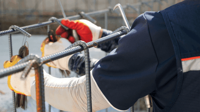 Worker tying rebar at a construction site