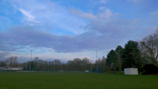 해질녘의 흐린 아늘 아래 넓은 잔디 축구장