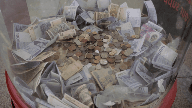 다양한 화폐로 가득 찬 기부 상자