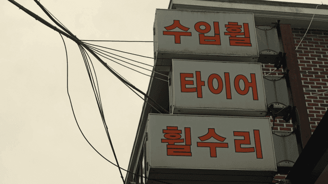 Tire shop sign with wires and brick wall