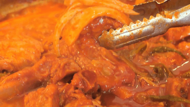 Piece of Spicy Braised Pork Galbi topped with vegetables