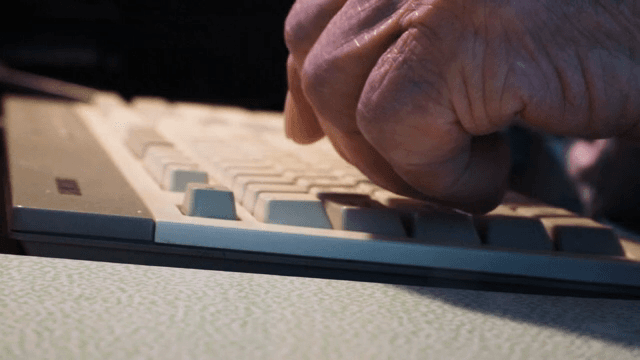 사무실에서 키보드를 치는 노인의 손