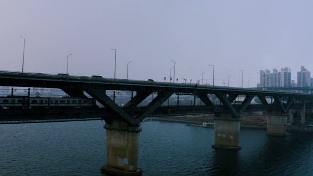 Cars and Subways Passing over a Bridge on a Snowy Day