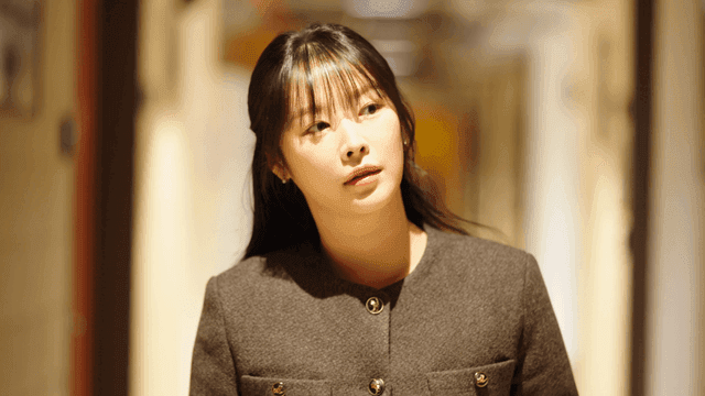 Young woman walking down hallway, looking to side
