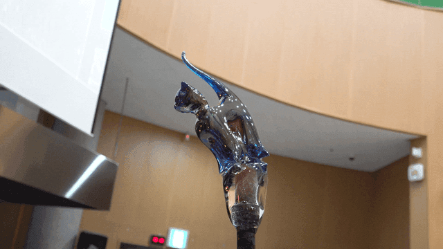 Glass sculpture of a cat in a room