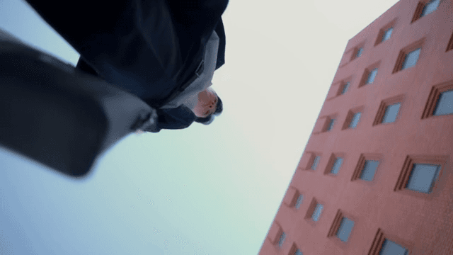 빨간 건물 앞에 선 서류가방은 든 남성