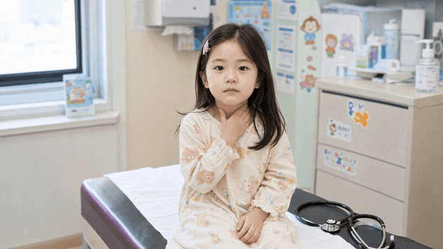 Female patient touching her neck in examination room