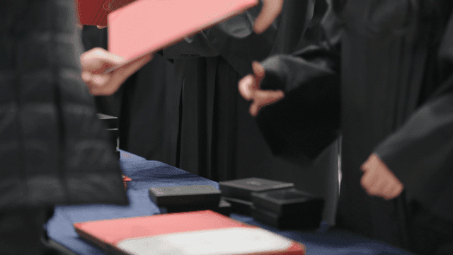 Graduates receiving their diplomas at graduation ceremony