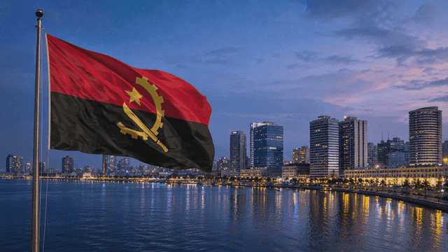 City night view with Angolan flag fluttering