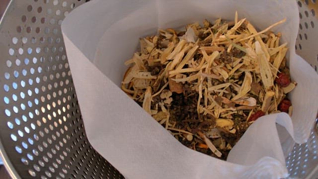 Oriental medicine ingredients in a fabric strainer inside a metal container