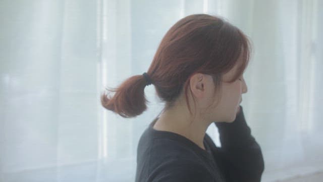 하얀 커튼이 있는 방에서 통화하는 여자