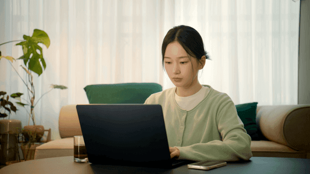 Tired woman working on laptop in living room