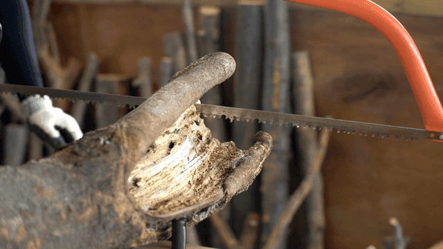 작업장에서 톱으로 통나무를 자르는 목수