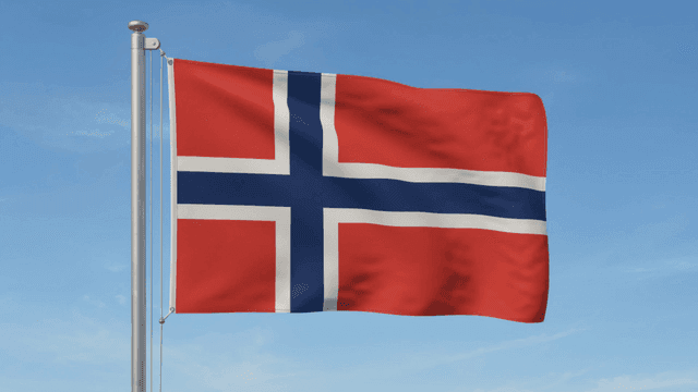 Norwegian flag waving against blue sky