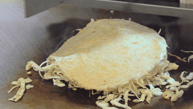 Cooking okonomiyaki on a hot griddle