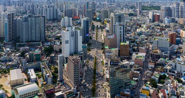 Busy traffic in downtown in Daegu with densely packed buildings at noon