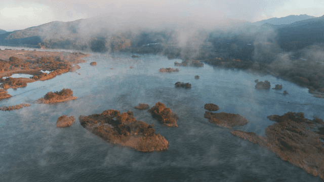 작은 섬이 있는 안개 낀 강 풍경