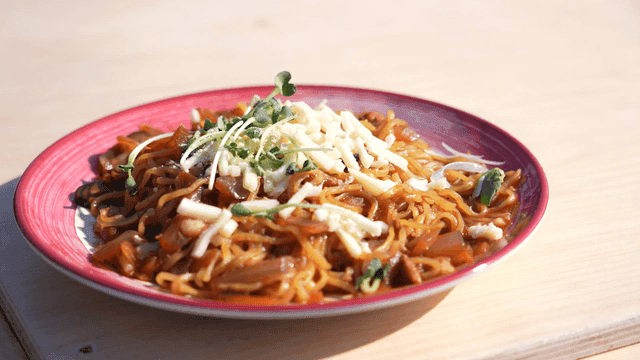 Plate of noodles with cheese and greens