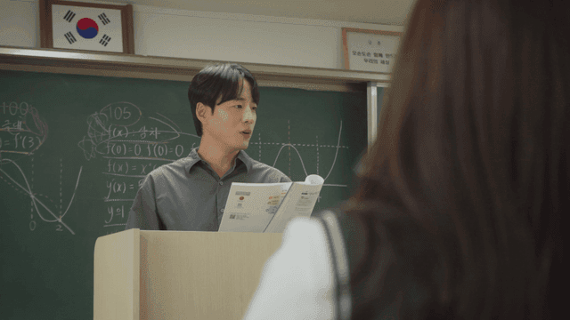 교과서를 보며 설명하는 선생님