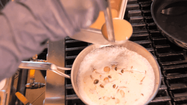 Chef preparing a creamy sauce on stove