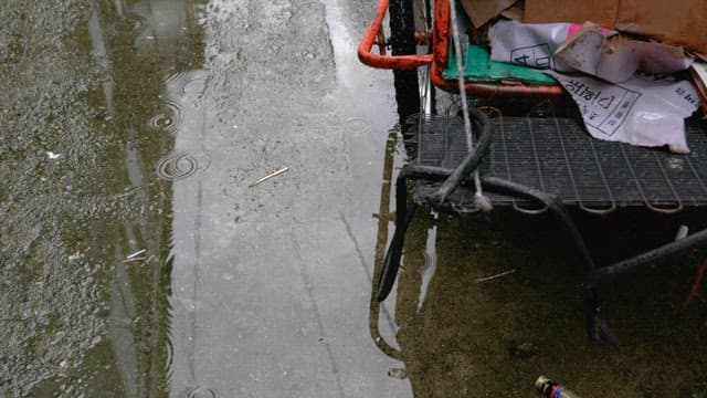 Alleyway on a rainy day with puddles and a cart