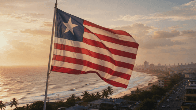 Liberian flag fluttering on beach at sunset