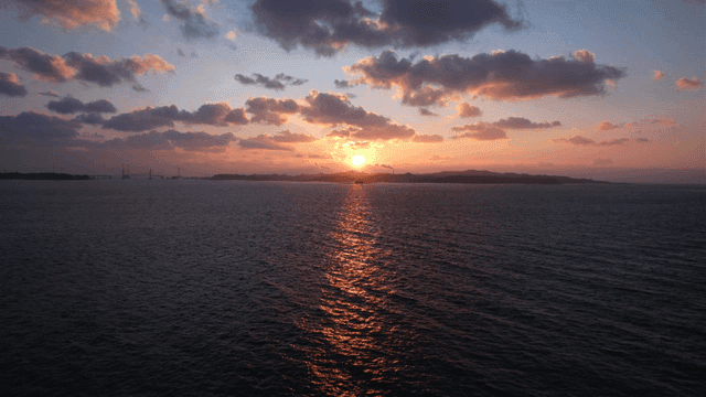 Sunset over the ocean with a lighthouse