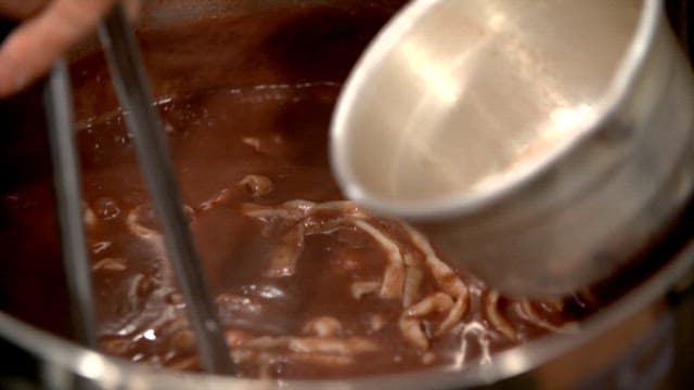 Thick red bean noodles cooked in a pot