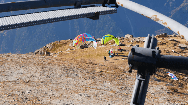 People preparing for paragliding on mountainside