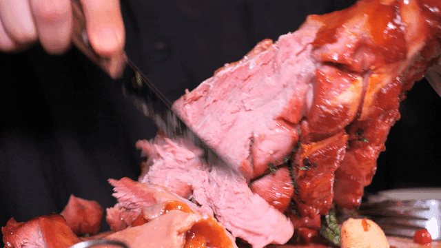 Slicing juicy roasted meat on a plate