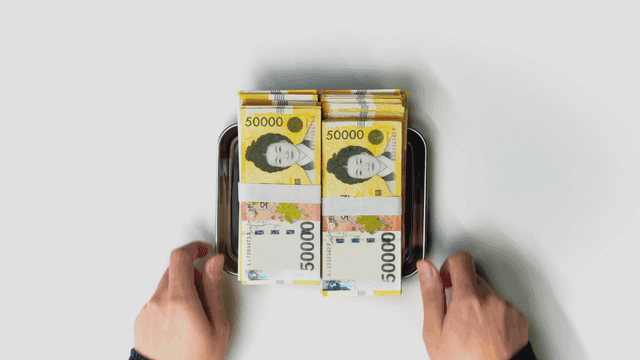 한국 화폐가 놓인 트레이를 건내 받는 손