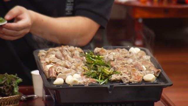 뜨거운 철판 위에서 구워지는 부추와 곱창