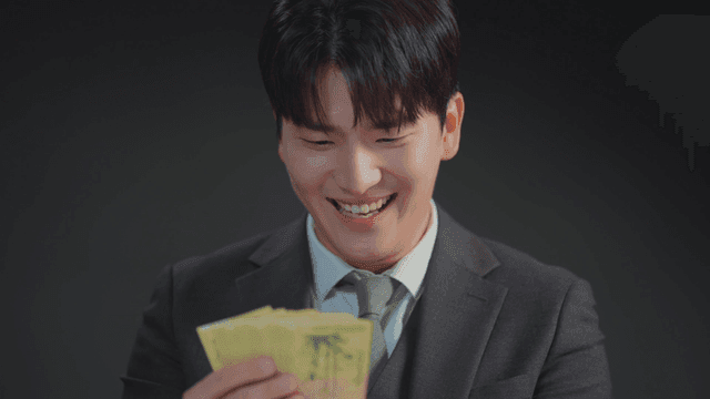 정장을 입은 남자가 돈을 보며 미소 짓는 모습