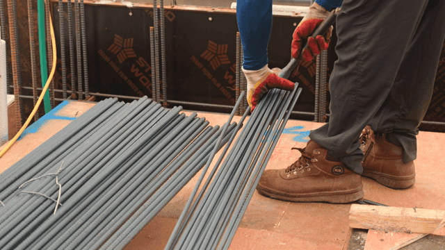 Worker arranging steel rods at a construction site
